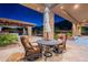Inviting outdoor patio with stone pillars, comfortable seating, and a view of the pool and beautifully landscaped backyard at 3118 W Glenhaven Dr, Phoenix, AZ 85045