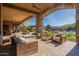 Elegant covered patio featuring stone columns, ample seating, and views of the pool and landscaped backyard at 3118 W Glenhaven Dr, Phoenix, AZ 85045