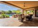 Covered patio features an outdoor dining area, a cozy seating area, and a refreshing pool at 3118 W Glenhaven Dr, Phoenix, AZ 85045