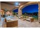 Beautiful outdoor living space featuring a stone archway, wood furniture, desert landscaping, and pool views at 3118 W Glenhaven Dr, Phoenix, AZ 85045