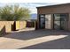 Desert landscaping with paved stones in the side yard leads to a detached structure featuring glass doors and a wooden gate at 3118 W Glenhaven Dr, Phoenix, AZ 85045