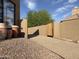 Gravel side yard featuring desert landscaping and a rustic wood gate, complementing the home's exterior at 3118 W Glenhaven Dr, Phoenix, AZ 85045