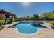 Stunning backyard pool with built-in spa, outdoor kitchen, fireplace, and desert landscaping at 3118 W Glenhaven Dr, Phoenix, AZ 85045