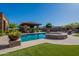 Luxury pool and spa with desert landscaping, covered kitchen, and patio, perfect for outdoor living at 3118 W Glenhaven Dr, Phoenix, AZ 85045