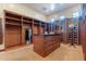 Spacious walk-in closet with custom wood built-ins, center island, and natural lighting at 3118 W Glenhaven Dr, Phoenix, AZ 85045
