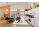 Bright kitchen features white cabinets, white island with white countertops, and orange walls with white trim at 3544 N Paseo Del Sol --, Mesa, AZ 85207