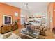 Bright open-concept living space with a dining table, modern tan sofa, and a white kitchen with island seating at 3544 N Paseo Del Sol --, Mesa, AZ 85207