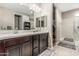 Well-lit bathroom with double sinks, granite countertop, and a glass-enclosed shower at 37645 W Santa Clara Ave, Maricopa, AZ 85138
