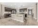 Modern kitchen with dark cabinets, stainless steel appliances, granite countertops, and a large center island at 37645 W Santa Clara Ave, Maricopa, AZ 85138