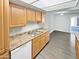 Well-lit kitchen with stainless steel sink, ample wood cabinets, laminate countertops, and modern flooring at 3810 N Maryvale Pkwy # 1070, Phoenix, AZ 85031