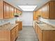 Well-lit kitchen with stainless steel sink, ample wood cabinets, laminate countertops, and modern flooring at 3810 N Maryvale Pkwy # 1070, Phoenix, AZ 85031