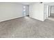 Spacious, carpeted living room with neutral walls and ample natural light coming from the front door at 3810 N Maryvale Pkwy # 1070, Phoenix, AZ 85031