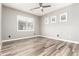 Bright bedroom with modern ceiling fan, wood look tile floors, and three windows at 42424 N Gavilan Peak Pkwy # 24206, Anthem, AZ 85086