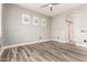 Bedroom with wood look tile floors, ceiling fan, and ensuite bathroom with sliding barn door at 42424 N Gavilan Peak Pkwy # 24206, Anthem, AZ 85086