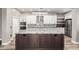 Modern kitchen features stainless steel appliances, white cabinetry, and a gray granite island with dark wood cabinetry at 42424 N Gavilan Peak Pkwy # 24206, Anthem, AZ 85086