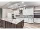 Modern kitchen with white cabinetry, a gray backsplash, stainless steel appliances and an island with a gray granite countertop at 42424 N Gavilan Peak Pkwy # 24206, Anthem, AZ 85086