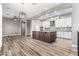 Open-concept living room and kitchen features a large kitchen island with grey granite countertop, white cabinets and stainless appliances at 42424 N Gavilan Peak Pkwy # 24206, Anthem, AZ 85086