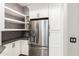 Pantry space, stainless steel refrigerator, and white cabinets in this kitchen offer ample storage at 42424 N Gavilan Peak Pkwy # 24206, Anthem, AZ 85086