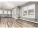Light-filled living room with wood-look tile floors, neutral walls, black railing and shuttered windows and sliding doors at 42424 N Gavilan Peak Pkwy # 24206, Anthem, AZ 85086