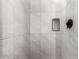 Shower with marble-look tiled walls and sleek, contrasting hardware and a niche at 42424 N Gavilan Peak Pkwy # 24206, Anthem, AZ 85086