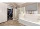 Bright bathroom featuring walk-in shower, soaking tub and large, walk-in closet with ample storage at 43303 N 44Th Ave, New River, AZ 85087