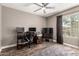 Bedroom with ceiling fan, hardwood floors and window with decorative curtains at 43303 N 44Th Ave, New River, AZ 85087