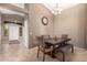 Elegant dining area featuring a modern chandelier, a dark wood table, and tile flooring at 43303 N 44Th Ave, New River, AZ 85087