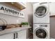 Laundry room featuring stacked washer and dryer, storage and a 'Laundry Co.' sign at 43303 N 44Th Ave, New River, AZ 85087
