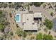 Aerial view showcases a modern home with a pool, patio, lush desert landscape, and private driveway at 4772 E Agave Ln, Cave Creek, AZ 85331