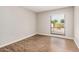 Bright bedroom featuring wood-look flooring and a window with backyard views at 5237 W Mountain View Rd, Glendale, AZ 85302