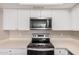 Kitchen featuring stainless steel microwave, oven, and range with white cabinets at 5237 W Mountain View Rd, Glendale, AZ 85302