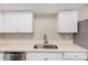 A kitchen sink with stainless steel fixtures and white cabinets and countertops at 5237 W Mountain View Rd, Glendale, AZ 85302