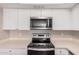 Modern kitchen featuring stainless steel appliances and bright white cabinetry at 5237 W Mountain View Rd, Glendale, AZ 85302