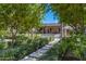 Lush backyard with a stone pathway leading to the house, pergola, and swimming pool at 6648 E Horseshoe Rd, Paradise Valley, AZ 85253