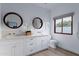Bright bathroom featuring double vanity with round mirrors and a window offering natural light at 6648 E Horseshoe Rd, Paradise Valley, AZ 85253