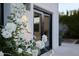 Exterior view of a white home with white flowers and black framed windows and doors at 6648 E Horseshoe Rd, Paradise Valley, AZ 85253
