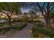 Inviting desert home with a stone walkway leading to a covered porch, enhanced by mature trees and landscaping at 6648 E Horseshoe Rd, Paradise Valley, AZ 85253
