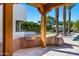 Outdoor kitchen and barbeque area featuring wood supports, a built-in grill and a lush backyard at 6648 E Horseshoe Rd, Paradise Valley, AZ 85253
