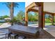 Outdoor kitchen and barbeque area featuring wood supports, a built-in grill, island and a lush backyard at 6648 E Horseshoe Rd, Paradise Valley, AZ 85253