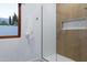 Modern shower with a glass door, white tiles, and a convenient built-in niche for storage at 6648 E Horseshoe Rd, Paradise Valley, AZ 85253