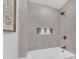 Modern bathroom features updated tile surround, tub, and built-in shower niche at 753 W Pampa Ave, Mesa, AZ 85210