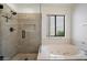 Bathroom featuring a relaxing soaking tub, a separate glass enclosed shower, and a bright window at 7565 N Vía De La Siesta --, Scottsdale, AZ 85258