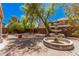 Landscaped backyard with a brick patio, mature trees, and a water fountain feature at 8037 W Mohave St, Phoenix, AZ 85043