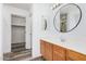 Bathroom vanity with a white countertop, wood cabinets, round mirror, and accessible walk-in closet at 8037 W Mohave St, Phoenix, AZ 85043