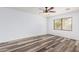 Bright bedroom with wood-look floors, ceiling fan, and natural light from the window at 8037 W Mohave St, Phoenix, AZ 85043