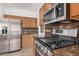 Well-lit kitchen featuring stainless steel appliances, wood cabinets, and marble countertops at 8037 W Mohave St, Phoenix, AZ 85043