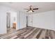 Spacious main bedroom featuring wood-look floors, ceiling fan, ensuite bath and walk-in closet at 8037 W Mohave St, Phoenix, AZ 85043