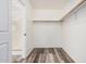 Bright walk-in closet with wood-look floors and a wooden closet rod at 8037 W Mohave St, Phoenix, AZ 85043