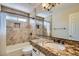Well-lit bathroom featuring granite countertop and tiled shower at 8136 E Cortez Dr, Scottsdale, AZ 85260
