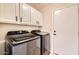 Laundry room with stainless steel washer and dryer and white cabinets at 8136 E Cortez Dr, Scottsdale, AZ 85260